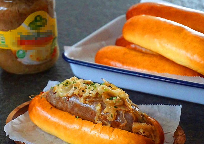 把前面我们做好的热狗面包从中间顺着划开,最后把加热的香肠或热狗肠