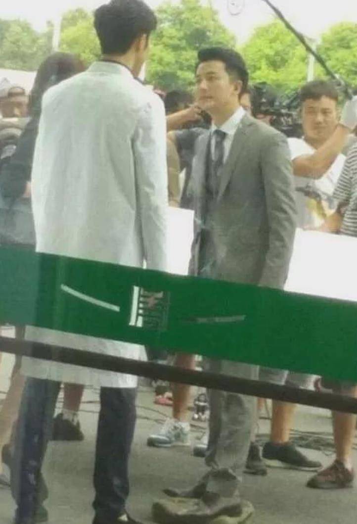 有人隔着玻璃门拍下了现场拍摄的花絮,黄轩脚下明显垫着一个箱子(看