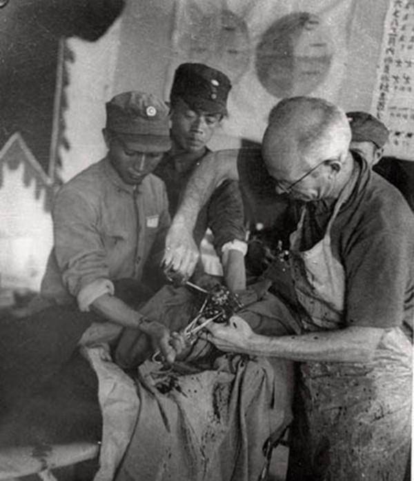 图为正在给受伤八路军战士做手术的白求恩.