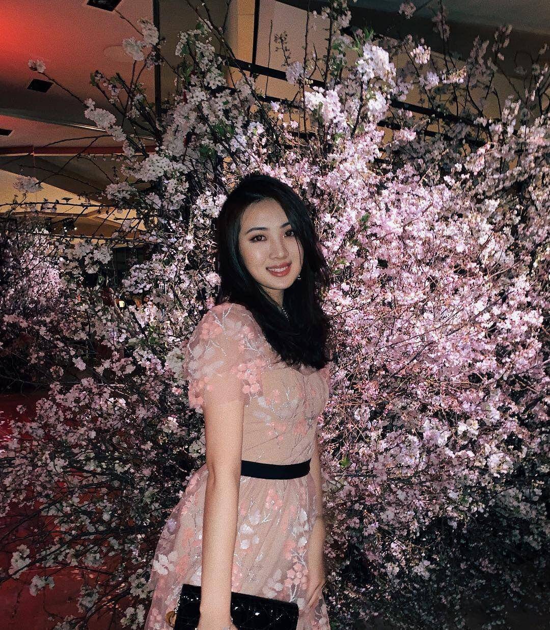 长相很明显的东方脸,肉嘟嘟的脸颊有点可爱,身穿粉色的花瓣长裙,收腰