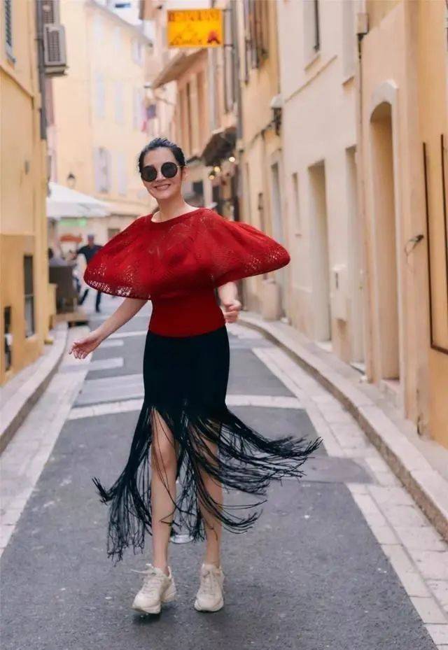 原创55岁许晴又去国外旅游穿红色风衣皮裤短发时髦洋气又减龄