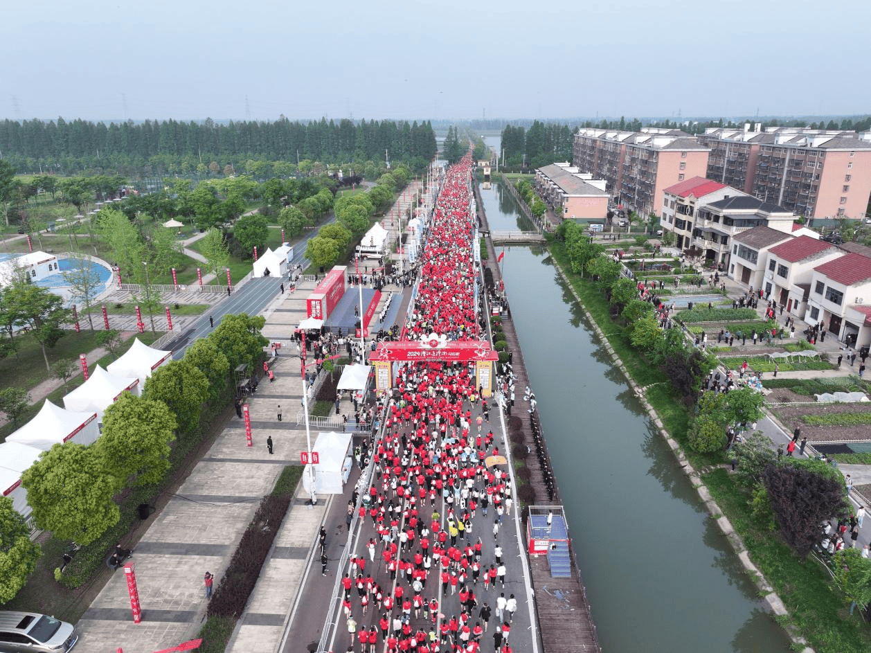 伴随着发令枪响,10000余名选手从潜江后湖管理区莫岭广场前飞驰而出