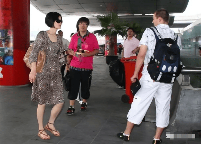53岁王菲彻底放飞!这打扮怀孕了谁都认不出,穿大妈裙踩人字拖走机场