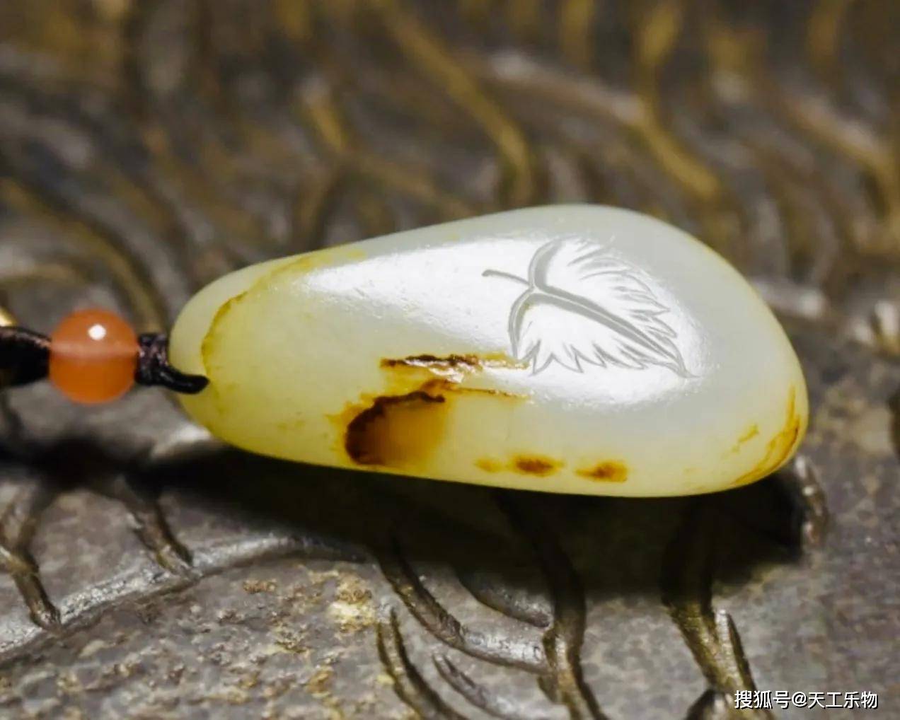 这件藏品由一颗和田玉的小独籽巧雕而成,玉色暖白柔和,玉质细腻温润