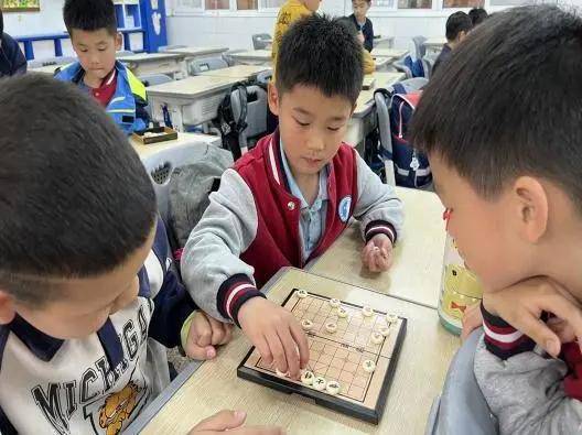 学校通过每周一节棋类课进课堂,通过全班普及优化人人都会下棋.