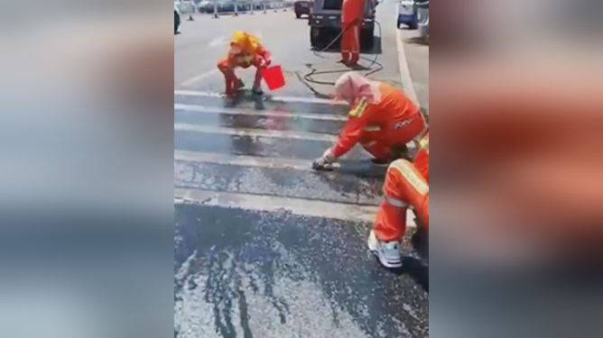 大连环卫工人用抹布擦斑马线引争议，在高温天气下是否有必要？-环卫工人在马路上扫地