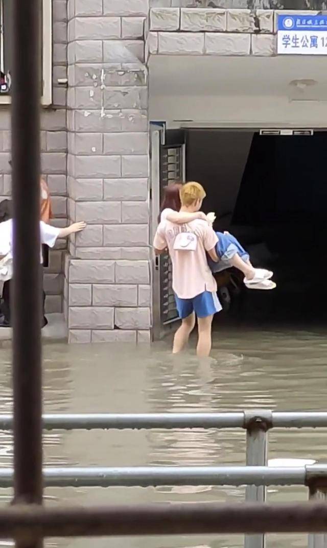 大雨过后校园路面积水,在学生公寓门口,男生公主抱女朋友蹚过去