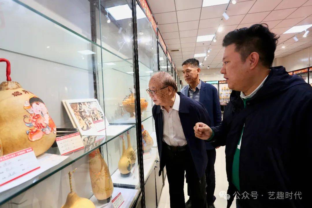 罗澍伟,于雪涛,张宝义在观看葫芦展品陈文君(左一)介绍葫芦展品孙晓东