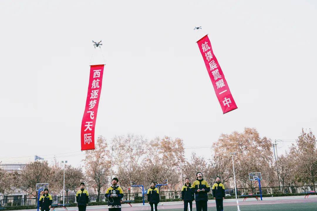 随着"西航逐梦飞天际,航模展翼耀一中"的横幅在无人机的操纵下缓缓