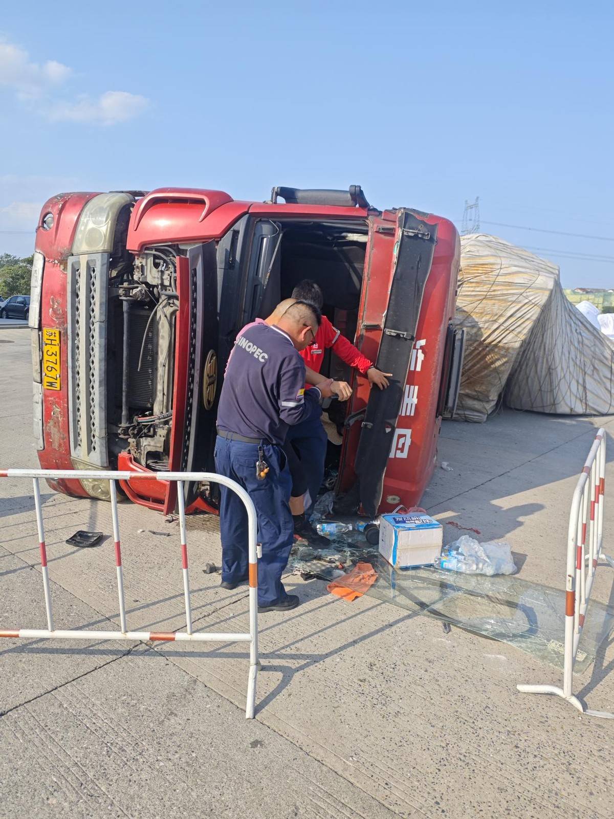 大货车突然侧翻 员工及时救助受伤司机