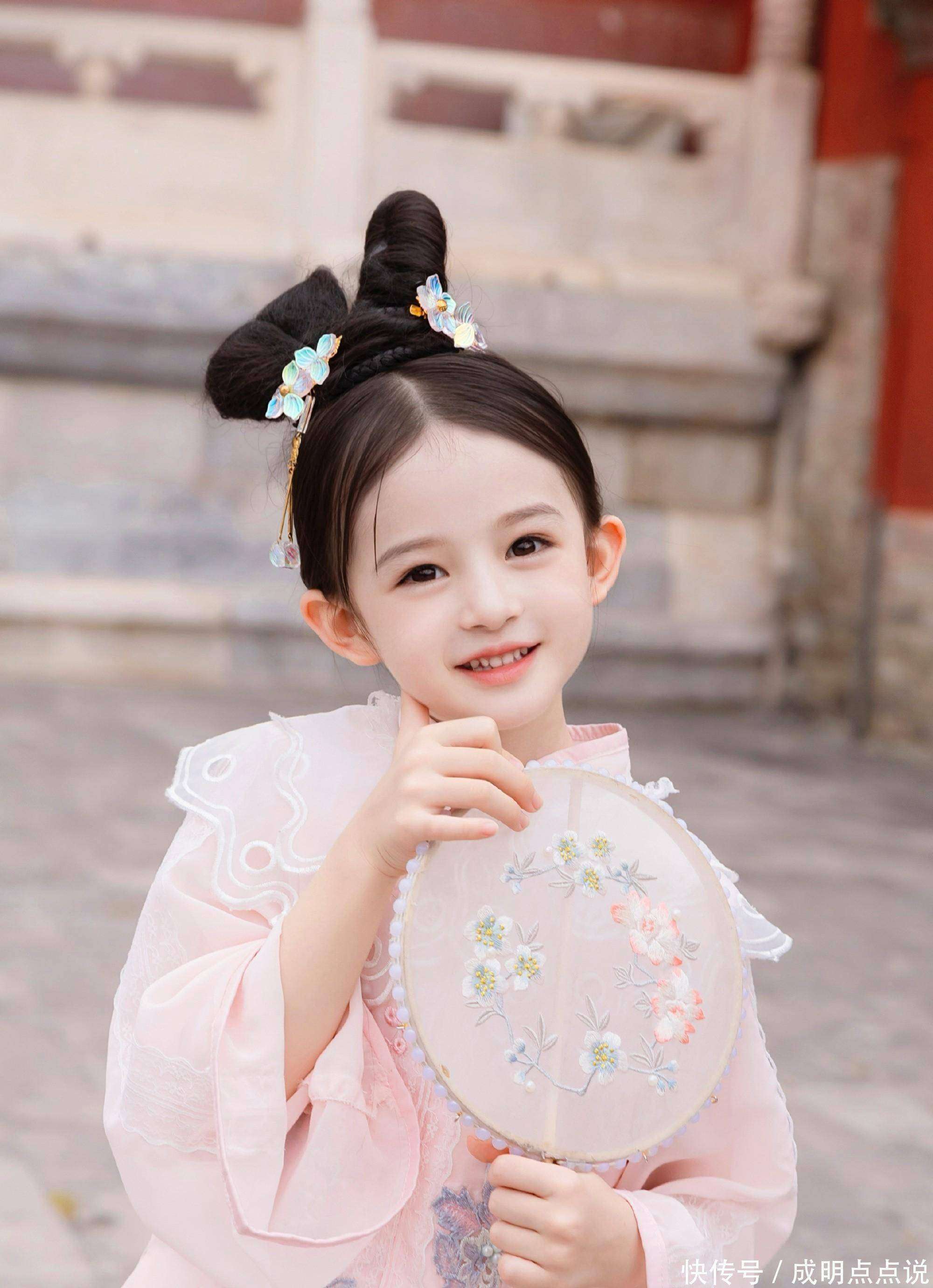 小姑娘披着乌黑柔顺的长发裹着粉嫩的毛绒外套白皙的皮肤仿佛在灯光