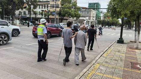 “我们是交警，不要着急，我们扶着你们走！”
