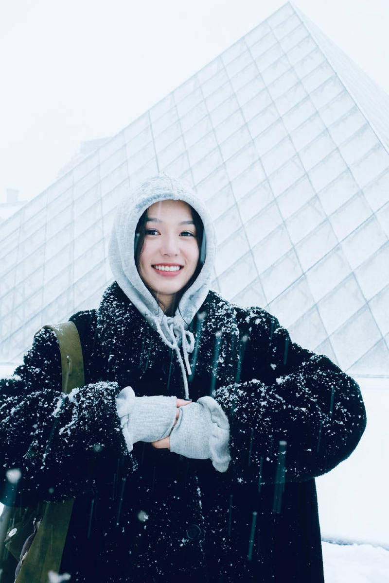 周也晒法国看雪照笑容灿烂 穿黑色大衣五官精致