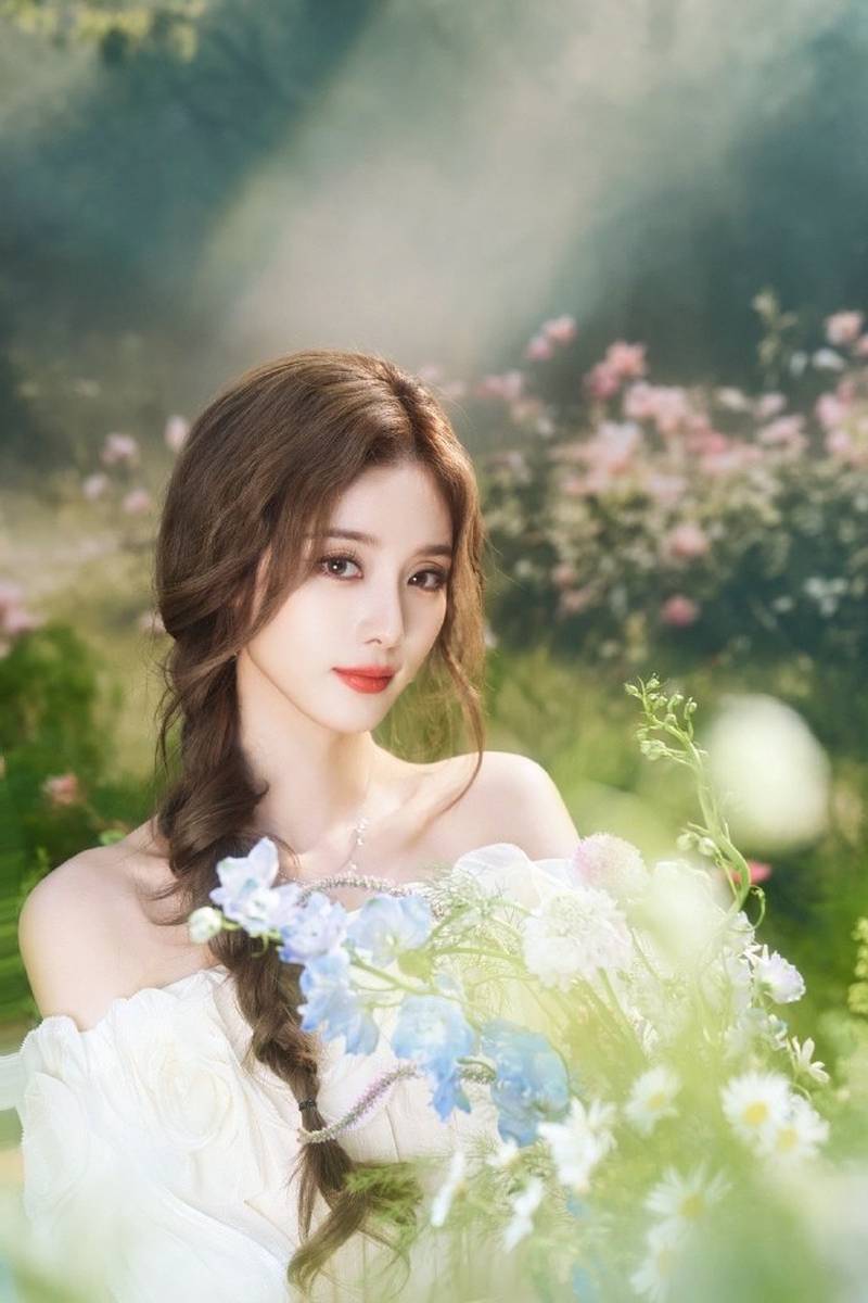 徐艺洋穿白裙与花海合照 光影衬出灵动氛围感