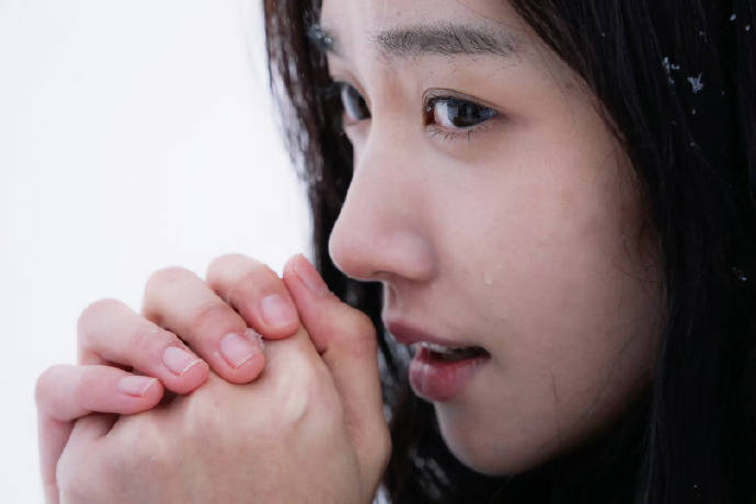 卢昱晓身穿深灰色大衣精雅干净 坐在雪中夸耀笑容