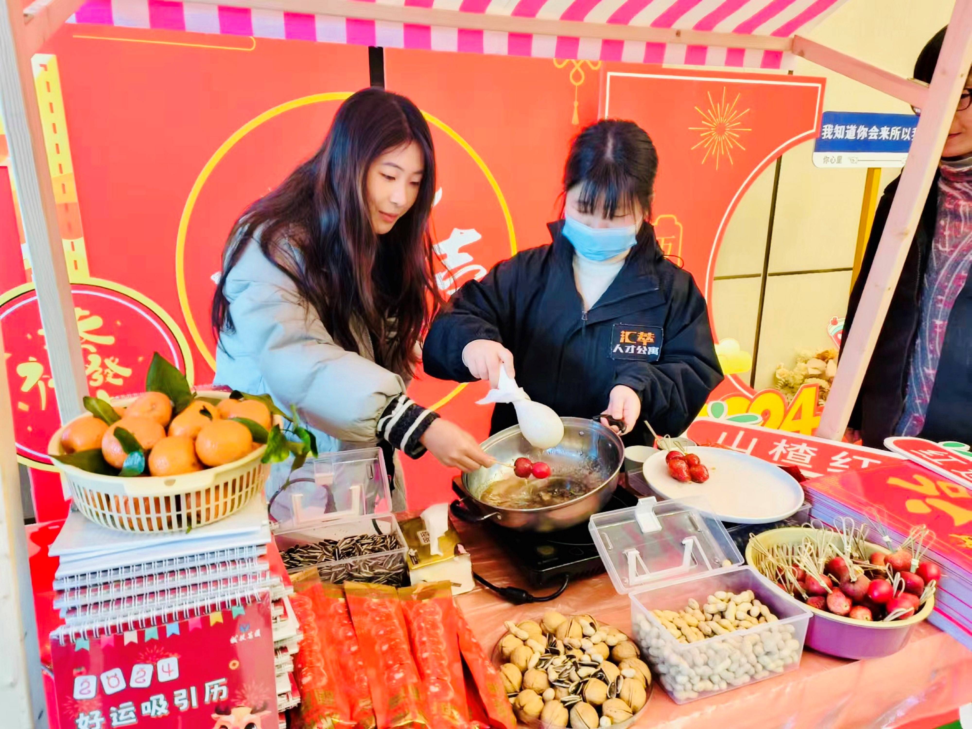 对活动现场做精心布置,准备了冰糖葫芦制作小亭,山楂和各种年货美食