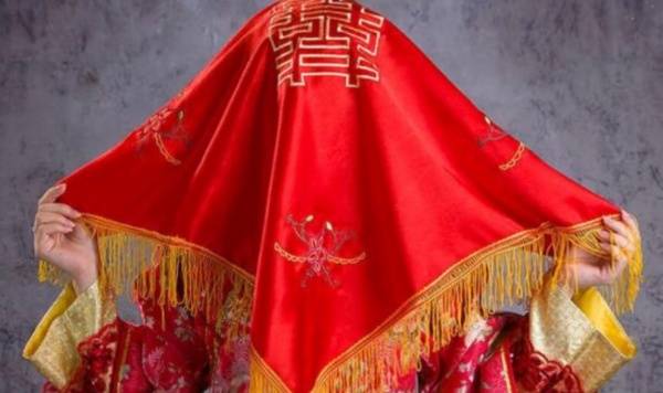 在洞房花烛夜,新郎会用秤杆或马鞭子轻轻挑起新娘的盖头,这一举动象征