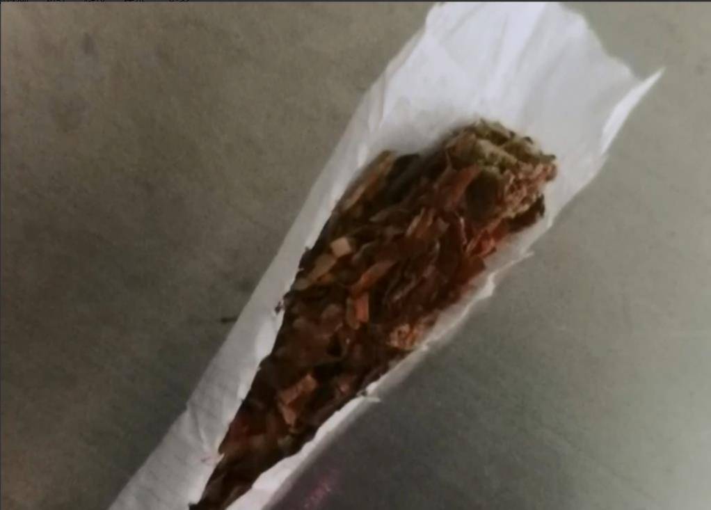 将香烟打开后民警发现,在烟的内部滤嘴被拆了下来,顶端的烟丝呈绿色