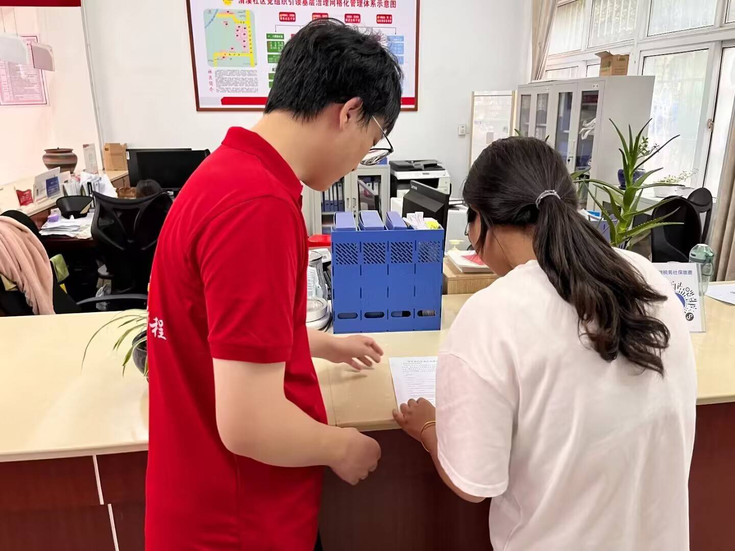 实践团给当地居民讲述调查问卷在活动现场,社区工作人员和实践团成员