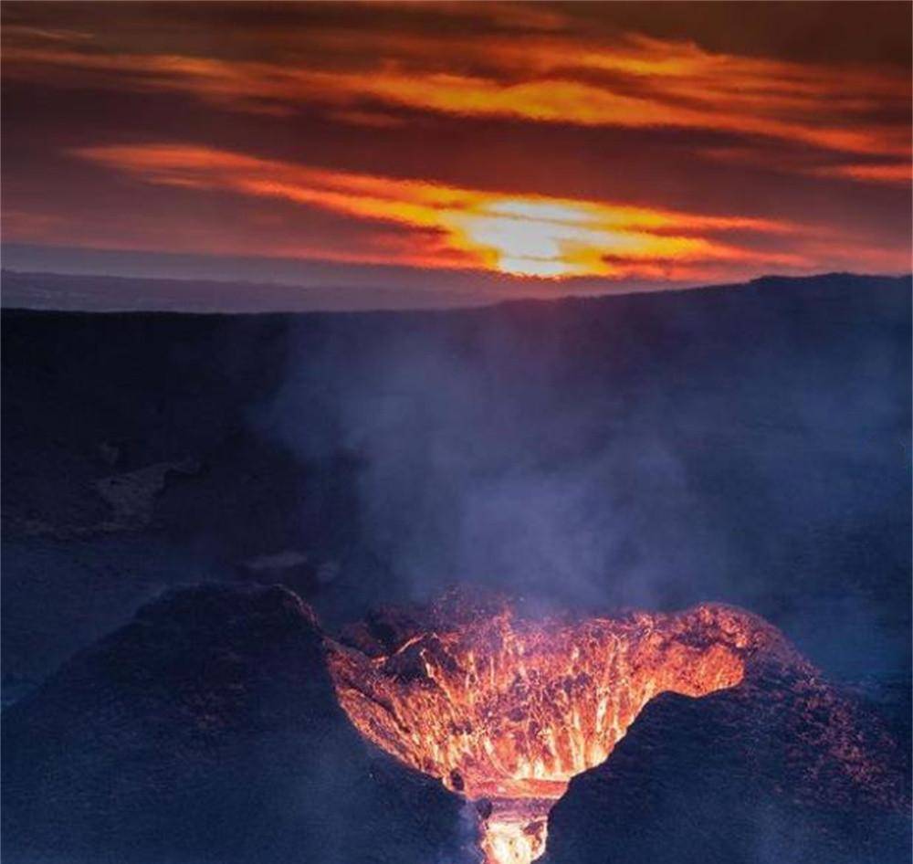 冰岛火山风暴前的宁静,在太阳落山的那一刻,岩浆从山的一侧倾泻而出