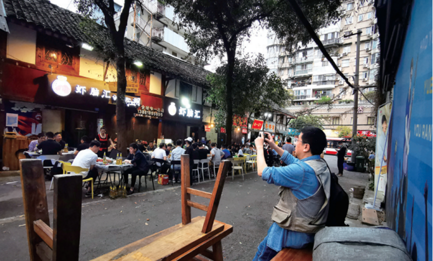 天色渐暗,小街照度按照餐馆的标准来讲是远远不够的,各家都在屋檐下或