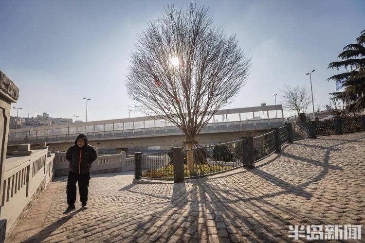 一位市民走在新鋪的馬牙石路上一位市民從熱河路沿著馬牙石路向下走