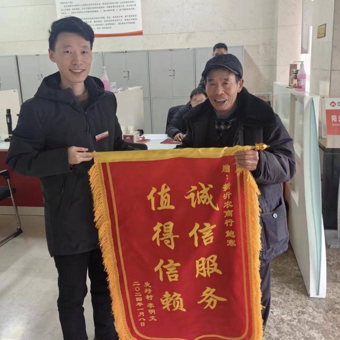港头镇史圩村李先生将印有"诚信服务,值得信赖"的锦旗送到了新沂农商