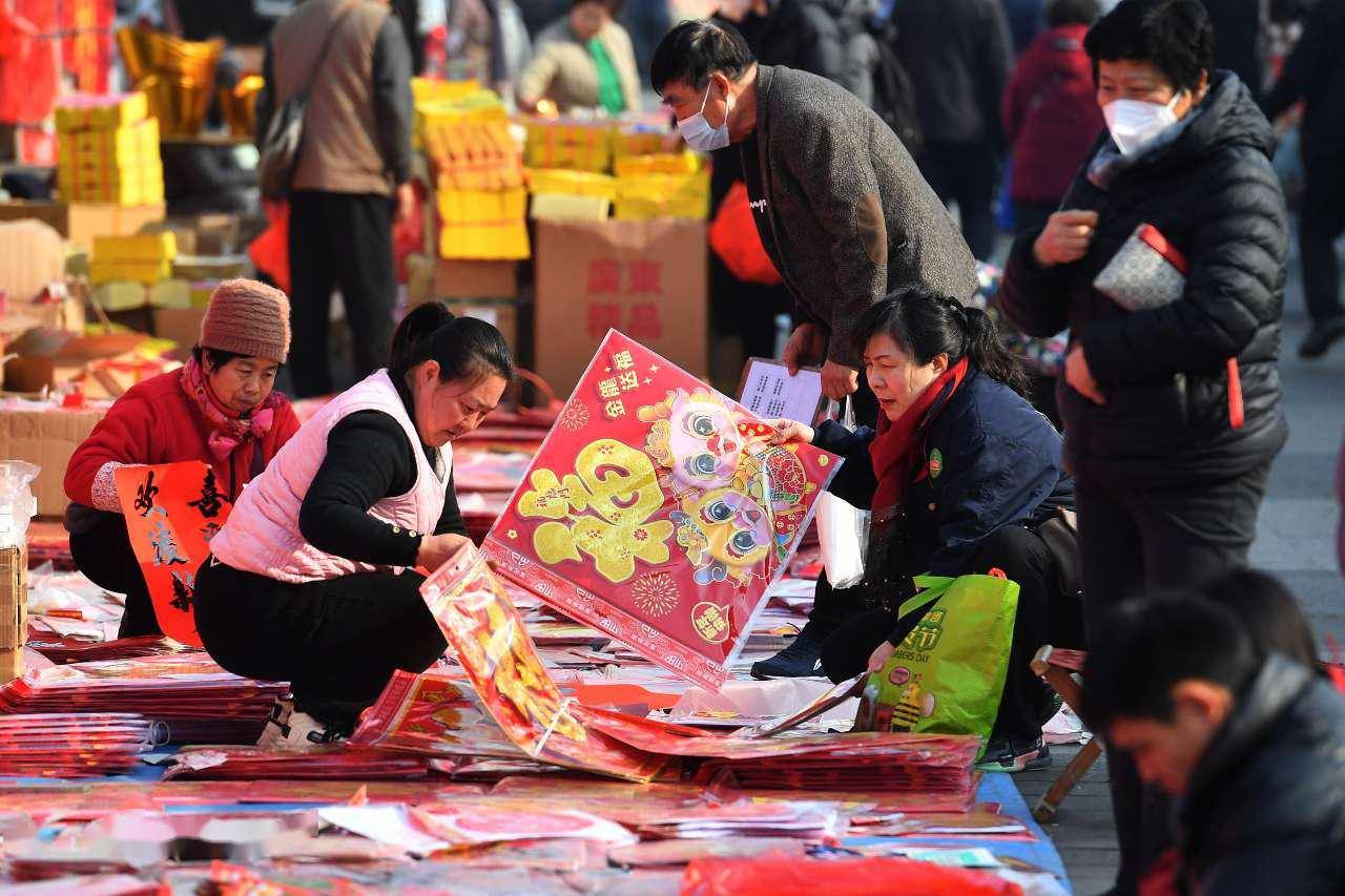 1月11日,在山东省青岛市崂山区周哥庄腊月年集上,一名小朋友推着童车