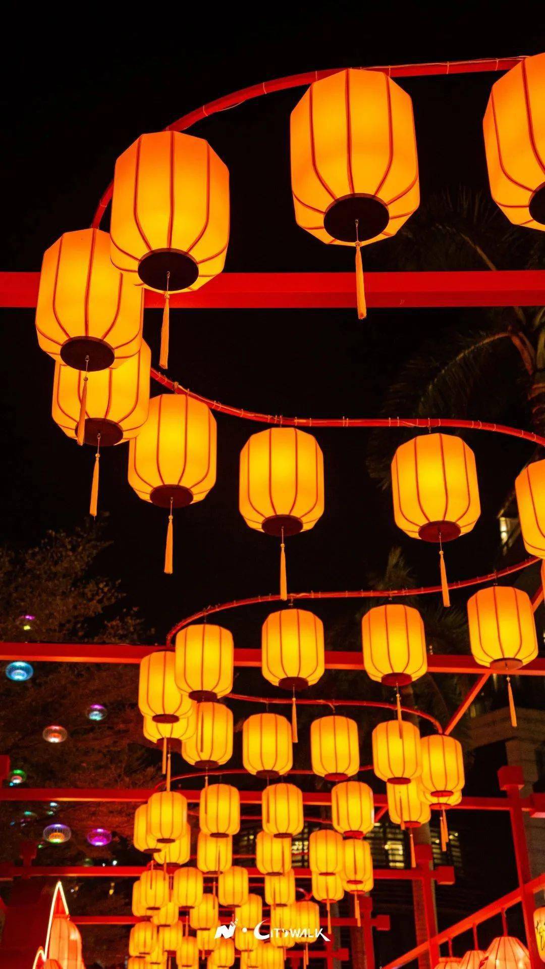 夜幕降临彩灯亮起灯笼样式多样将整条百米长街照耀得灯火通明十分喜庆