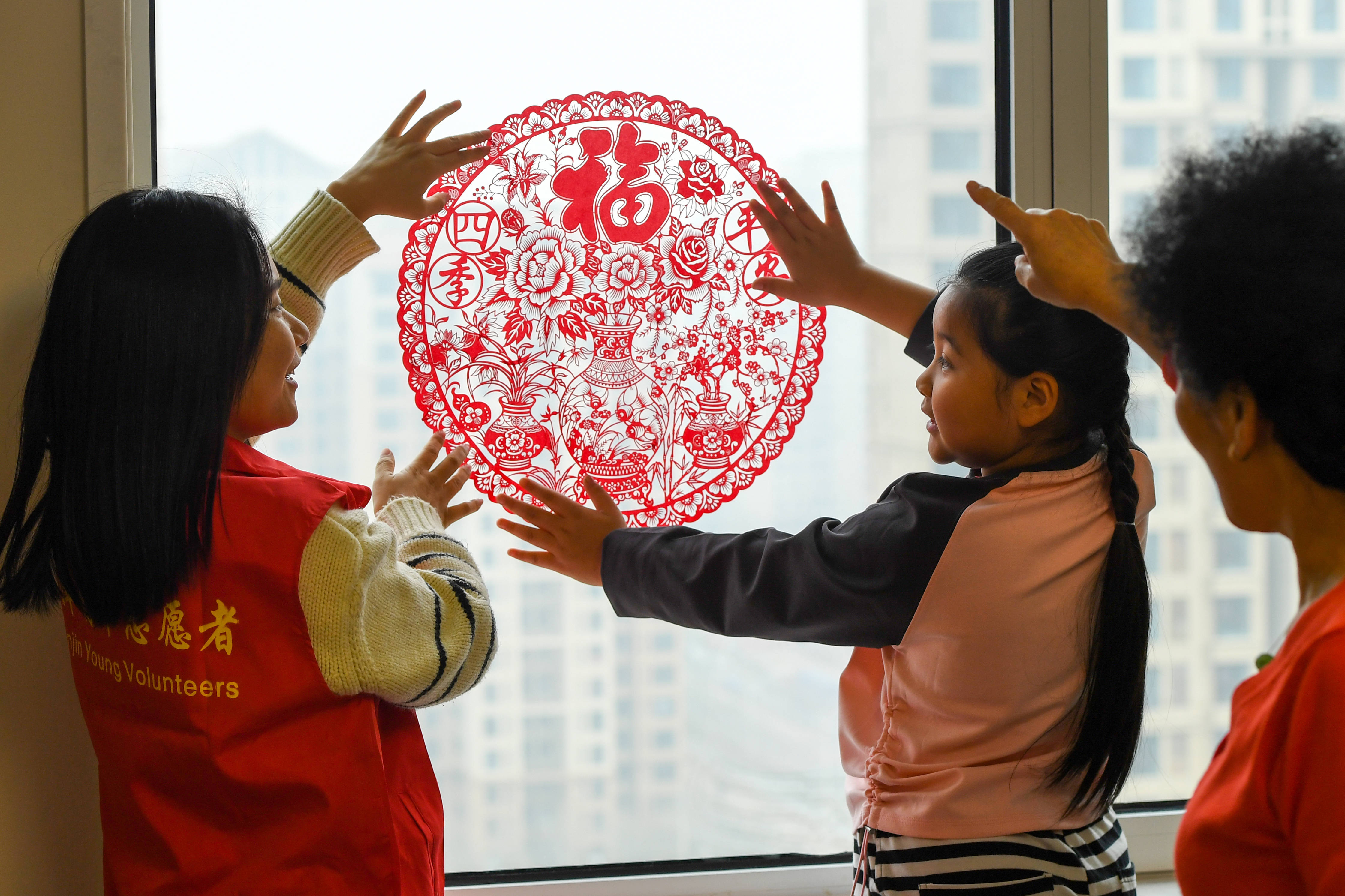 临近春节,家住仁静家园小区的马立君大姨和小孙女正在新家挂吊钱,贴