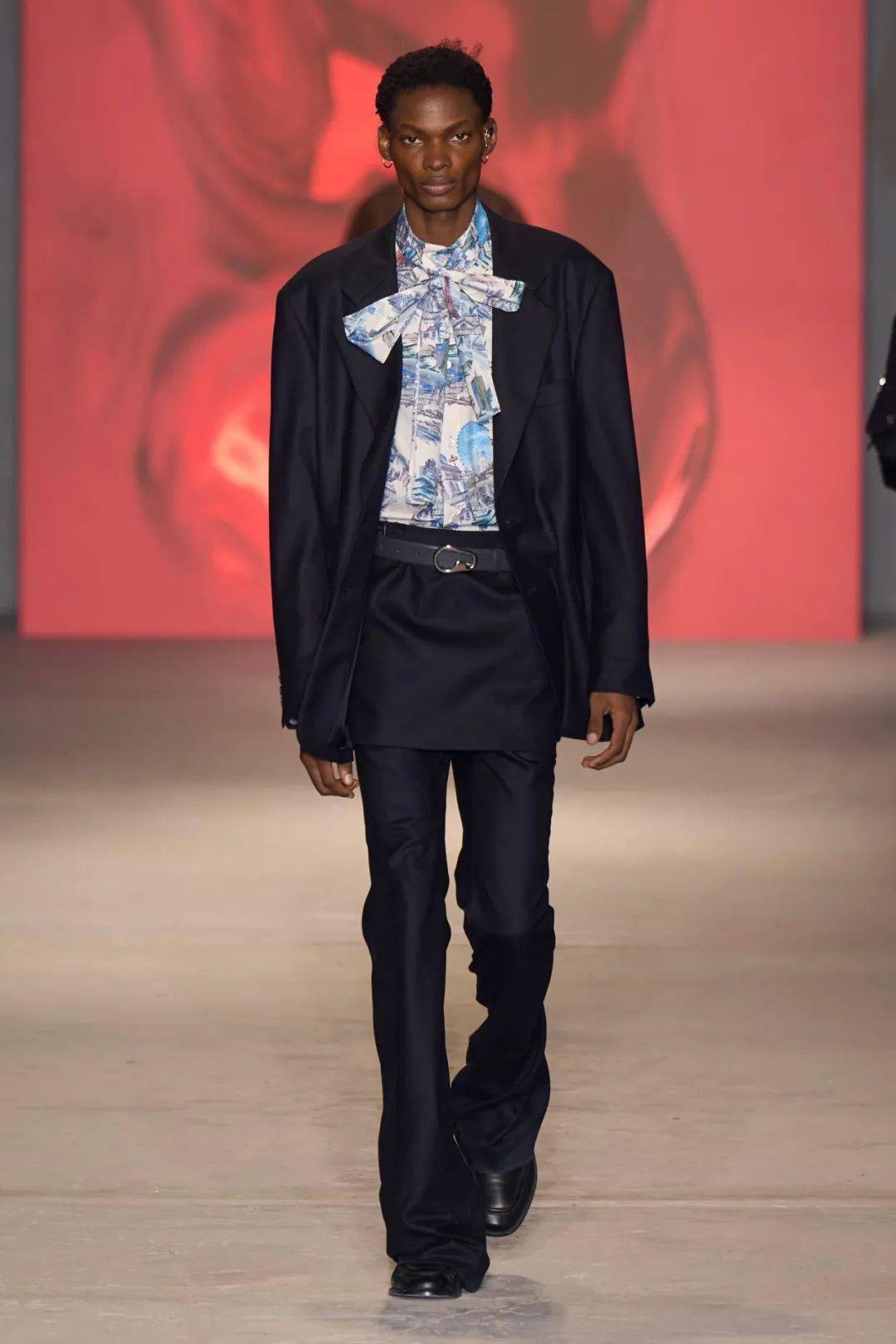 如传统黑色西装套装,内搭选择天蓝色花衬衫,胸前系上蝴蝶结,在不失