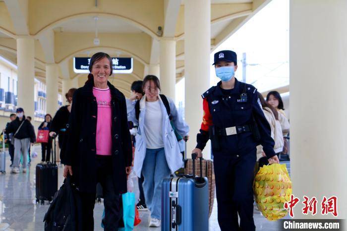 图为吴婧玮护送越南籍返乡旅客范氏出站.