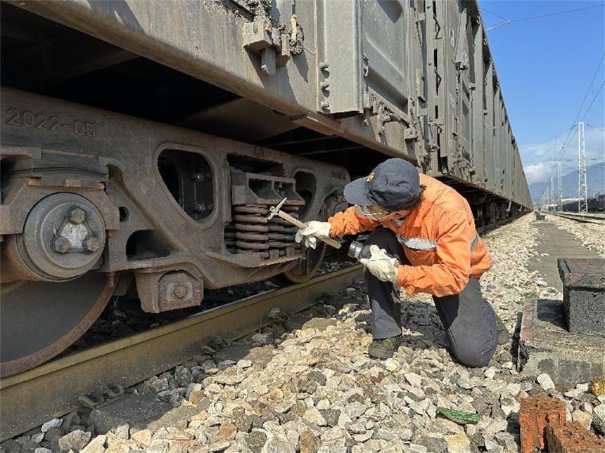 工作人员在检查车辆缓解阀拉杆吊架.覃泽诚摄