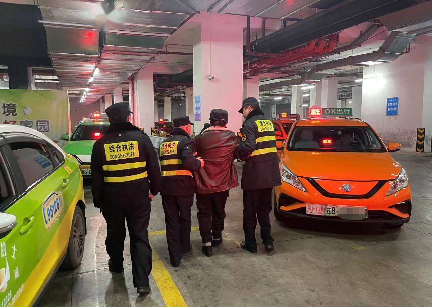 城管队员与男子一起扶着其父亲,缓慢地走向出租车候车区,约100米的