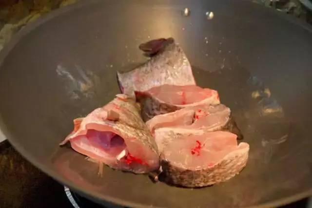 把鲈鱼清洗干净后切成大块,放进中火的油锅中煎到外皮金黄酥香,形成