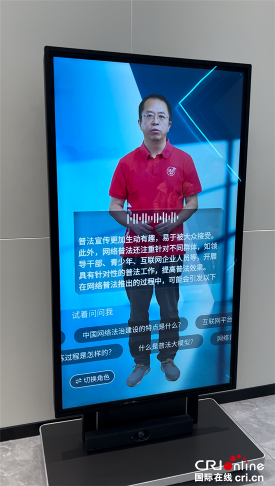 数字人"老周"谈网络普法(摄影 王鲁平)活动现场的屏幕前,一位名叫"老