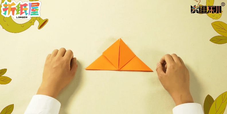 然后再将折纸表面左右两个角向中间折起,第三步:折出一个双三角形.