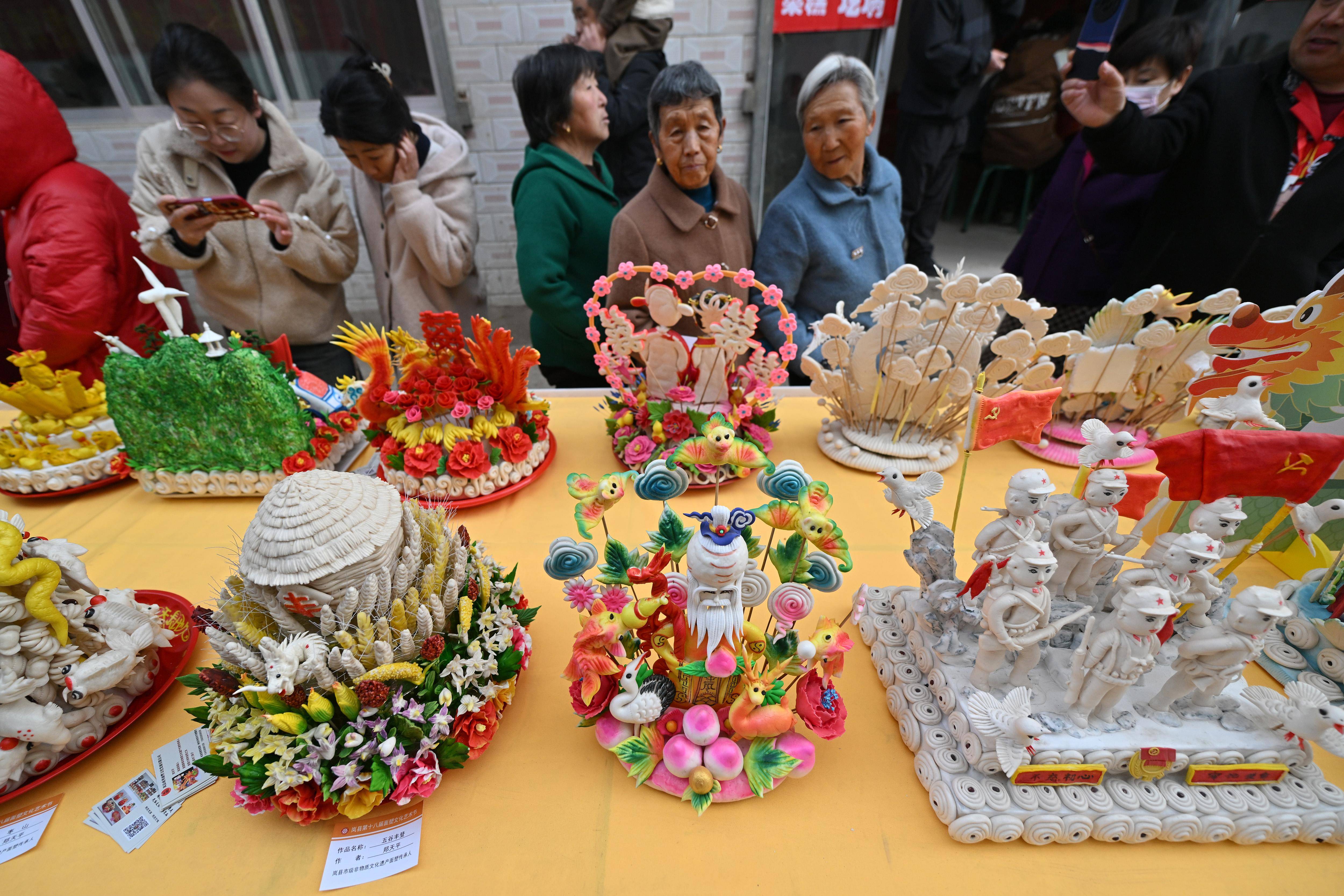 3月28日,在山西省岚县岚城镇,人们欣赏面塑作品