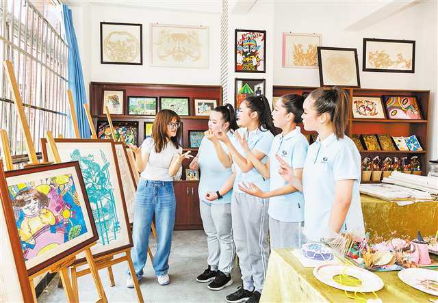 5月17日,南川区特殊教育中心,老师为聋哑学生讲解美术作品.