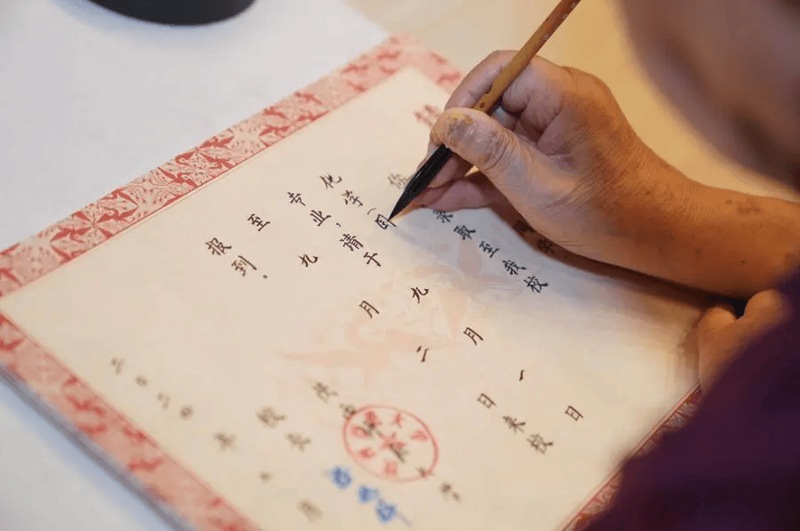 一名退休教师在陕西师范大学为新生手写录取通知书.
