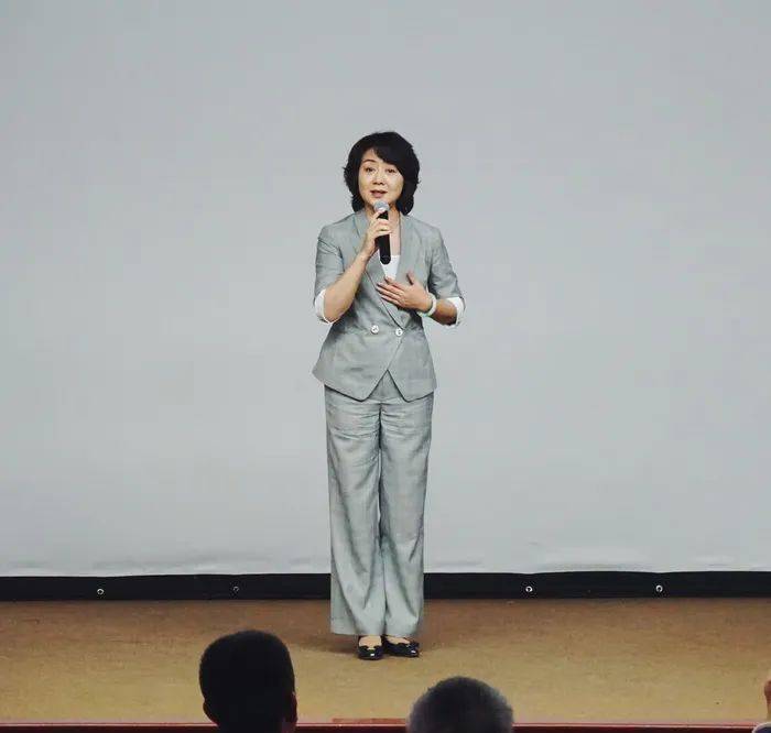 短发打理得一丝不苟,与整体装扮相得益彰,展现出她作为演讲者的专业与