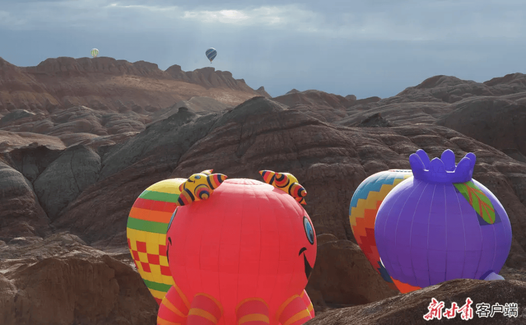 喷射火焰,扶起吊篮……活动现场,36具各式各样的热气球相继从彩色丘陵