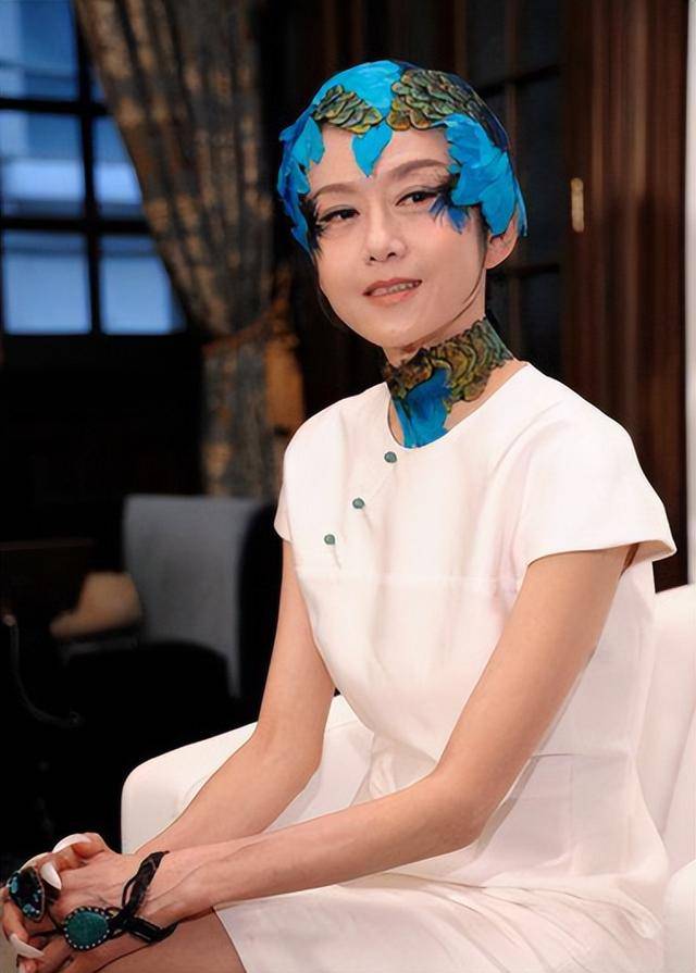 杨丽萍在自家花园摘苹果,胳膊上肌肉明显,66岁留长发像36岁