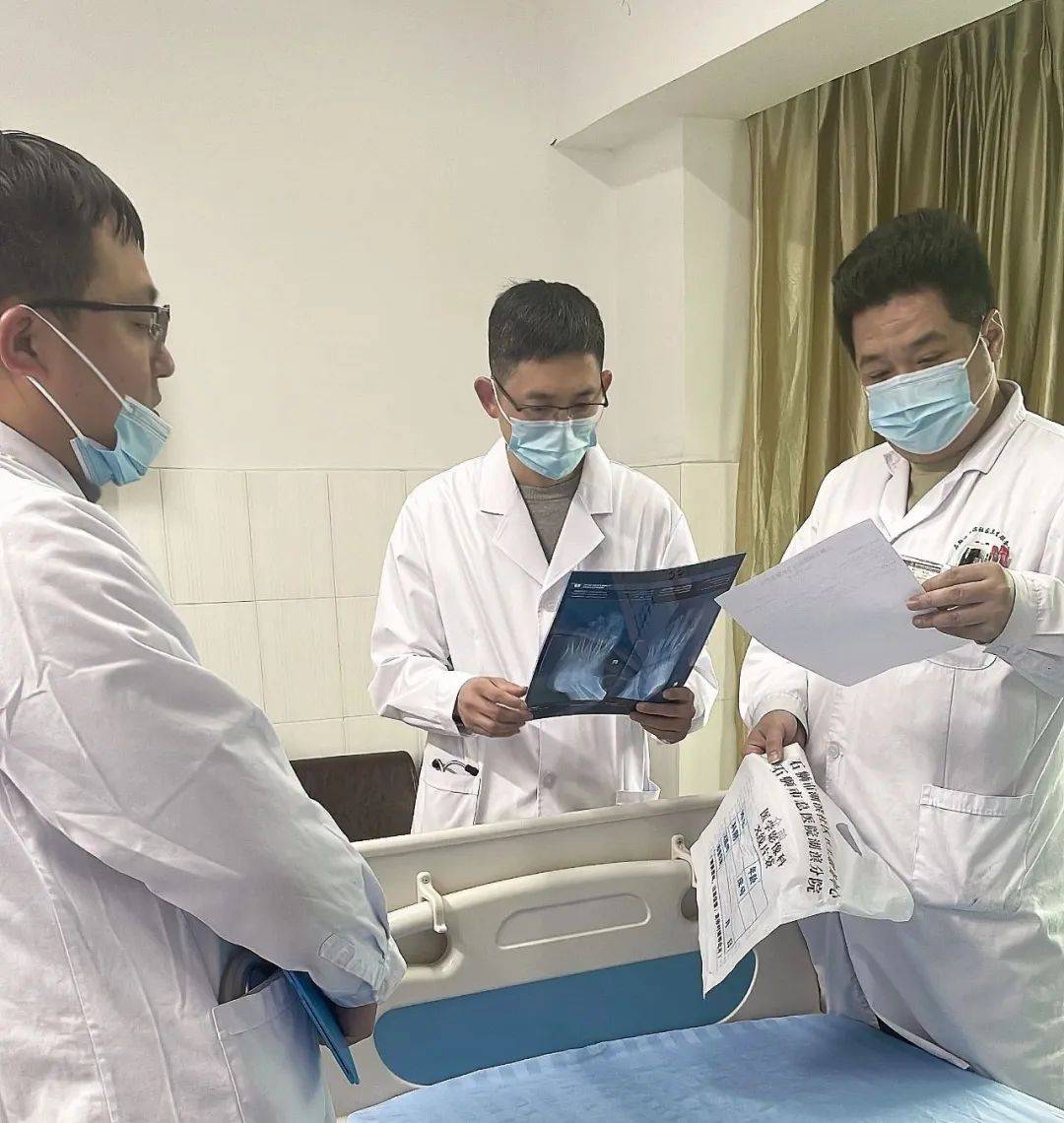 查房时,郭焕钢仔细查看患者的病历资料,与主治医生深入探讨治疗方案